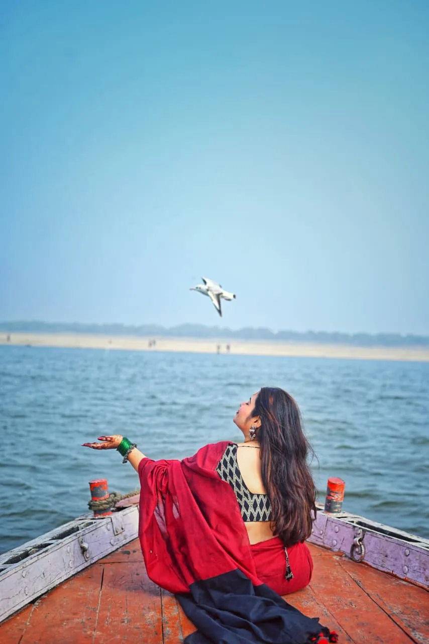 A visitor looking out across the Ganga from the ghats, photographed by One Moon Studio in Varanasi.