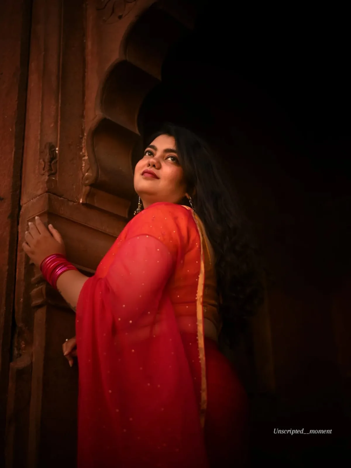 A traveller framed in a carved doorway of the old city, photographed by One Moon Studio in Varanasi.