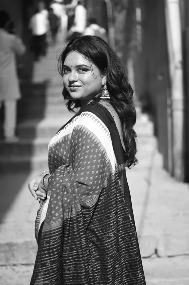 A visitor seated on the riverfront steps in the early morning, photographed by One Moon Studio in Varanasi.